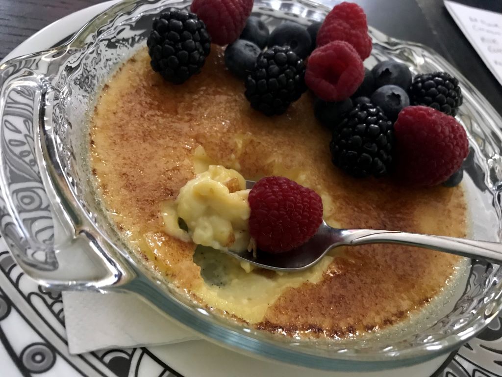 Homemade vanilla bean creme brulee with mixed fresh berries